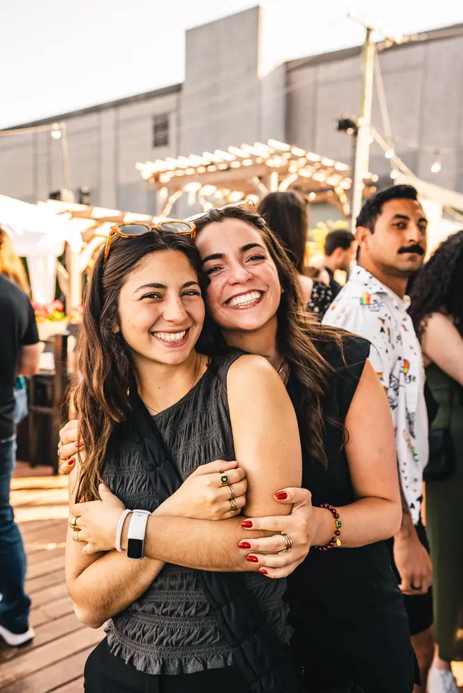 Duas amigas abraçadas sorrindo