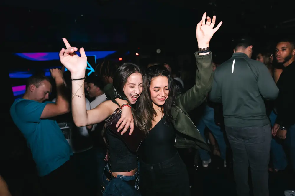 Amigas dançando de braços para cima no WeFunk